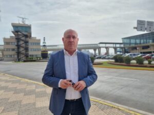 Hombre de pie con fondo verde y puerto de Melilla