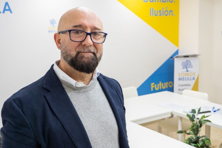Hombre con barba y gafas en una sala de reuniones