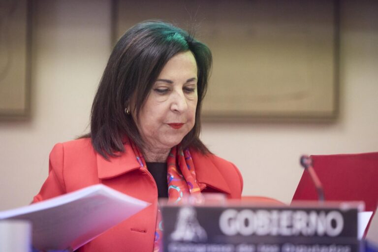 Margarita Robles durante una reunión, con documentos en mano.