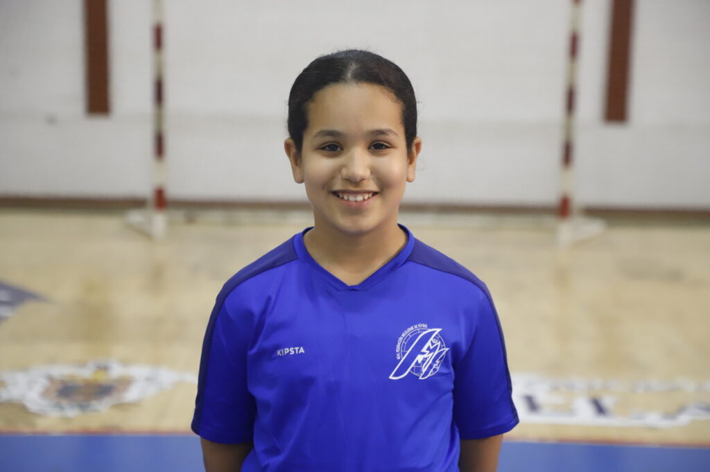 Niña sonriente en uniforme de fútbol sala azul