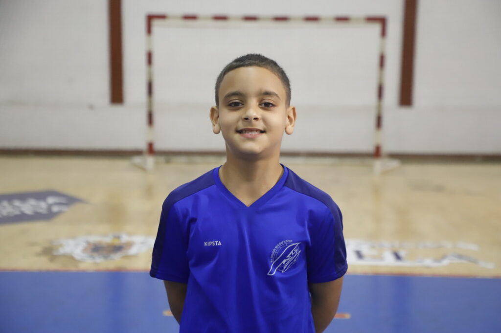 Niño sonriente con camiseta azul en un gimnasio