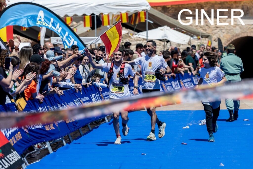 Tío y sobrino corriendo en una carrera con el público animando