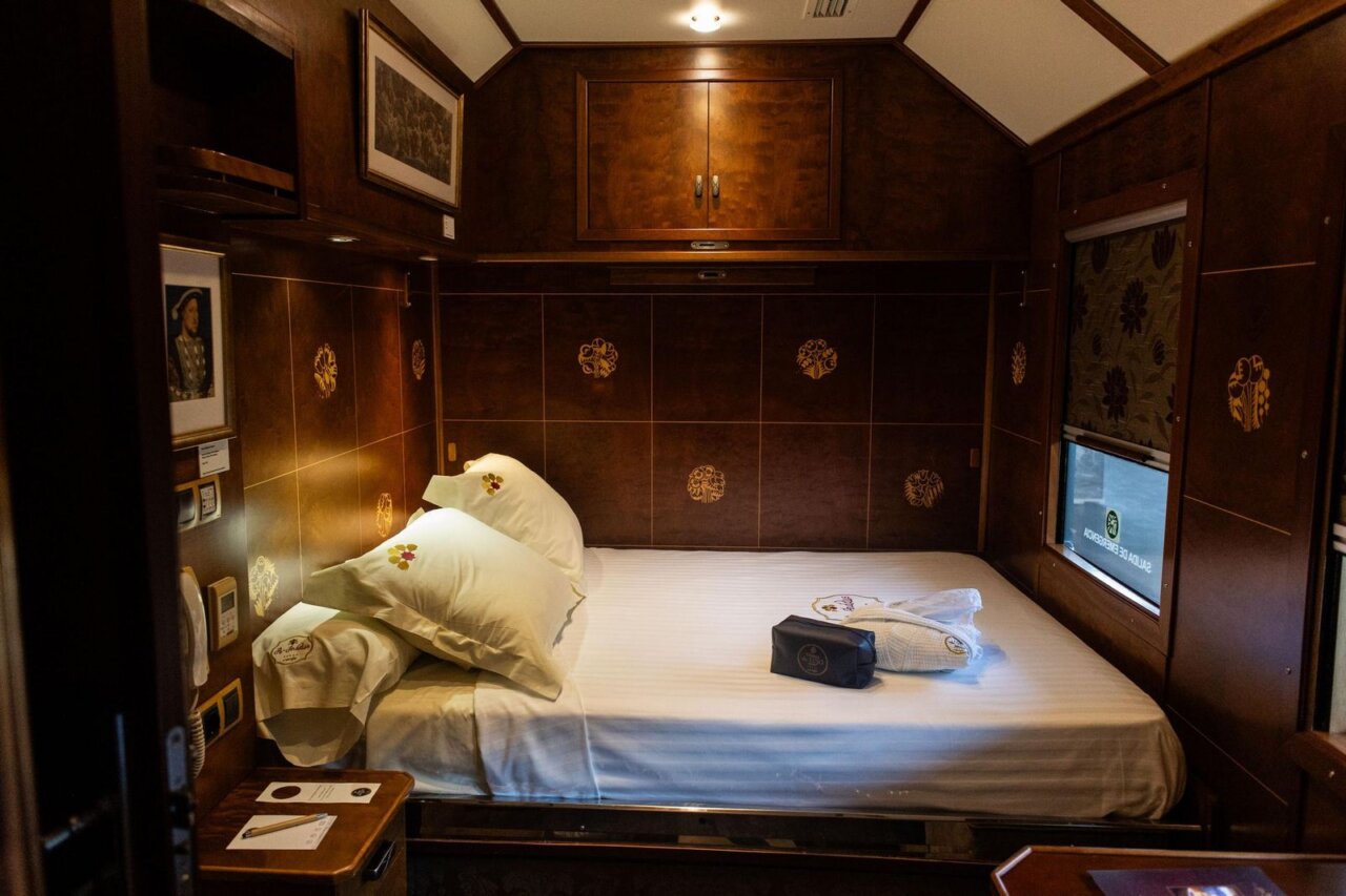 Interior de una habitación del Tren Al Ándalus con cama y decoración elegante