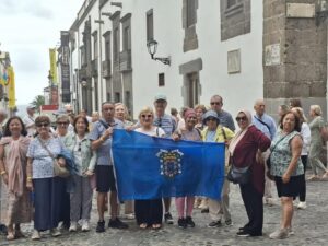 Grupo de personas mayores sosteniendo una bandera en una calle de Melilla