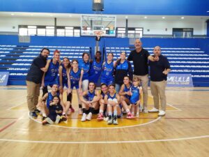 Equipo de baloncesto femenino celebrando victoria en la cancha