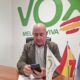 Político de Vox revisando su teléfono en una oficina