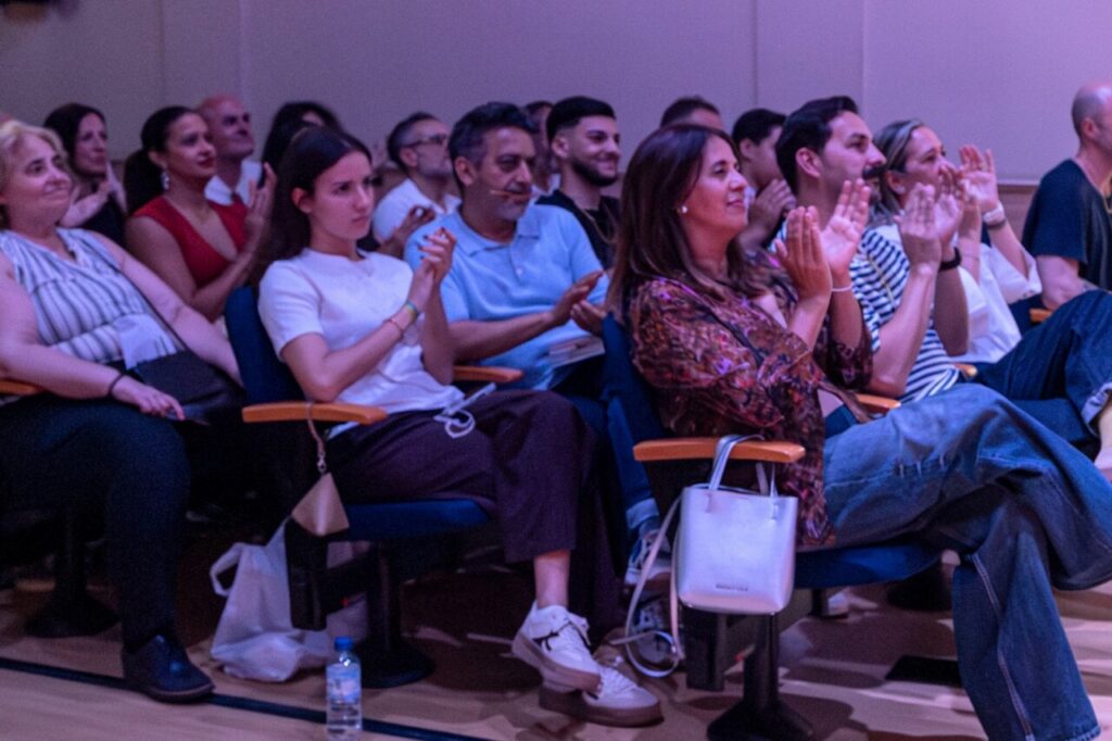 Público aplaudiendo durante la actuación de Diego del Morao en la UNED