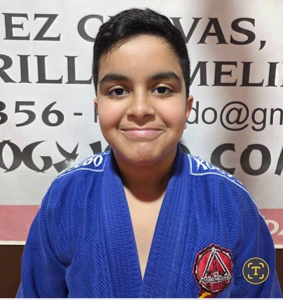 Joven judoka de la Escuela KogyJudo de Melilla sonriente con su uniforme azul