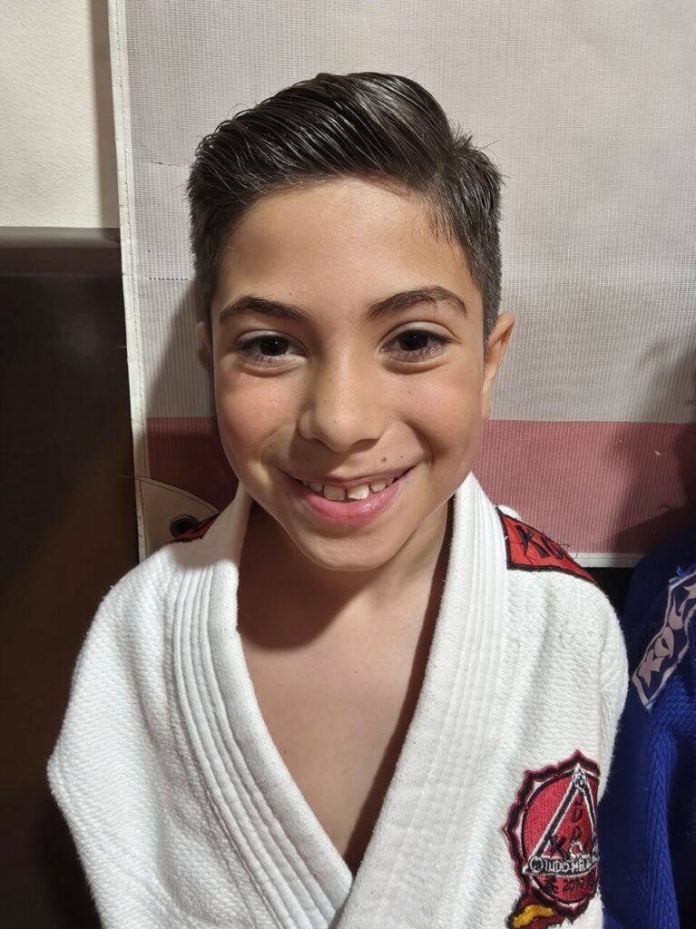 Niño sonriente con judogi en la Escuela KogyJudo de Melilla