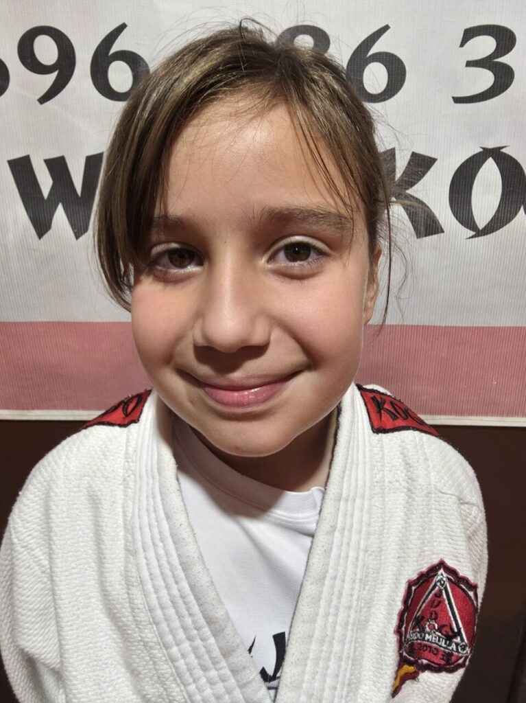 Niña sonriendo con uniforme de judo en la Escuela KogyJudo