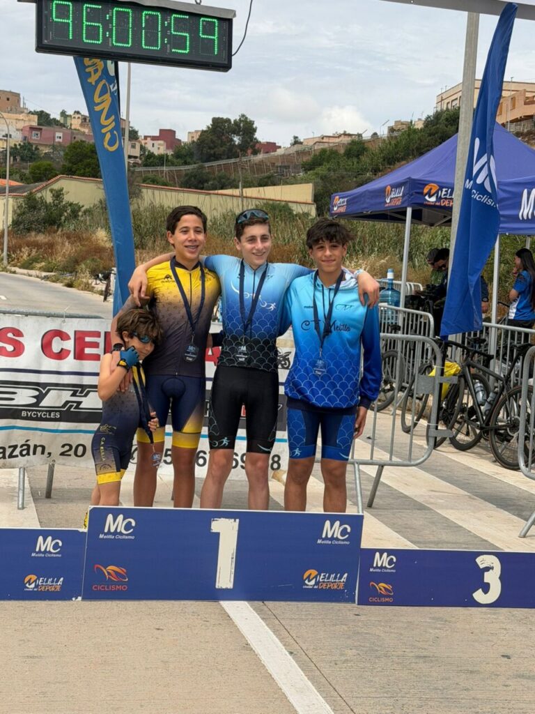 Cuatro jóvenes ciclistas posando en el podio tras una carrera