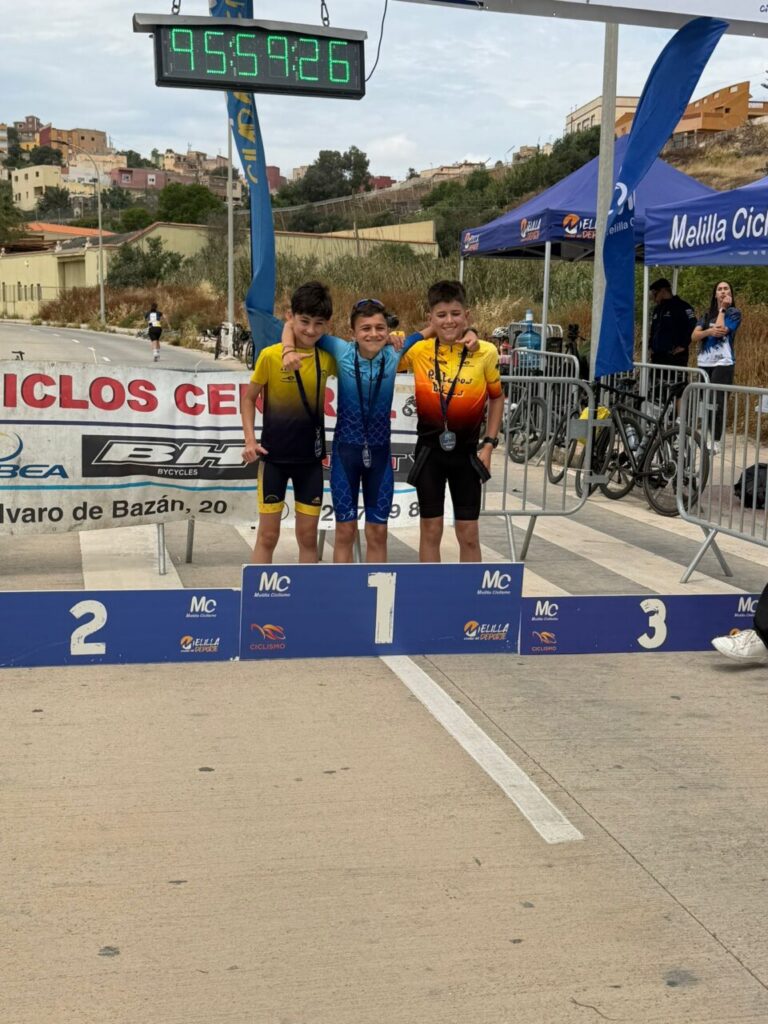 Tres jóvenes ciclistas en el podio del GP Orbea-Ciclos Central en Melilla.