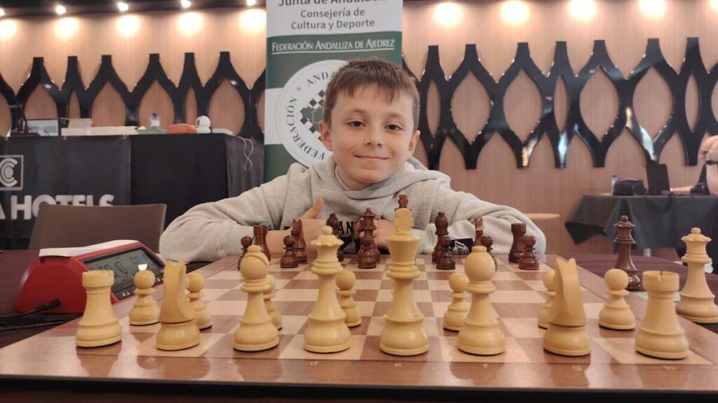 Niño jugando ajedrez en un torneo con piezas en el tablero