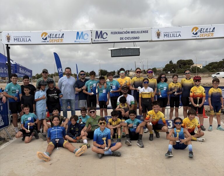 Grupo de niños ciclistas con trofeos en el Trofeo UNED