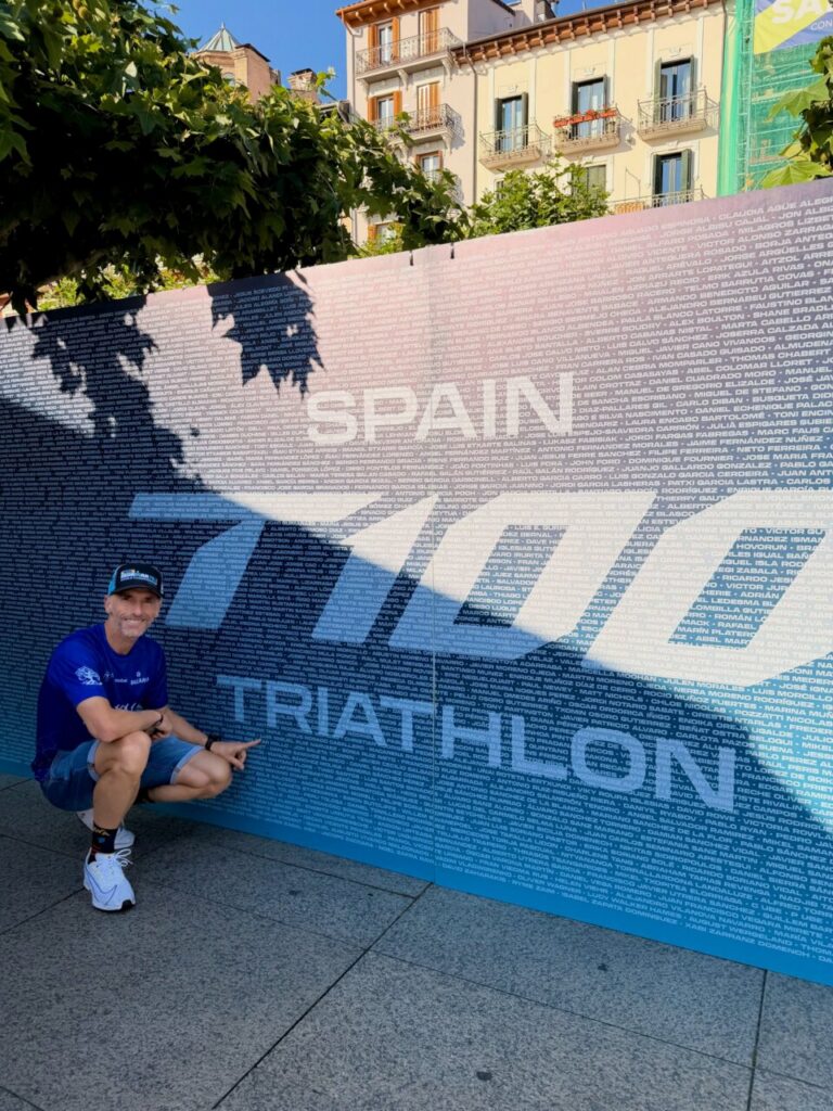 Luismi Ruiz posando junto al cartel del triatlón en Pamplona