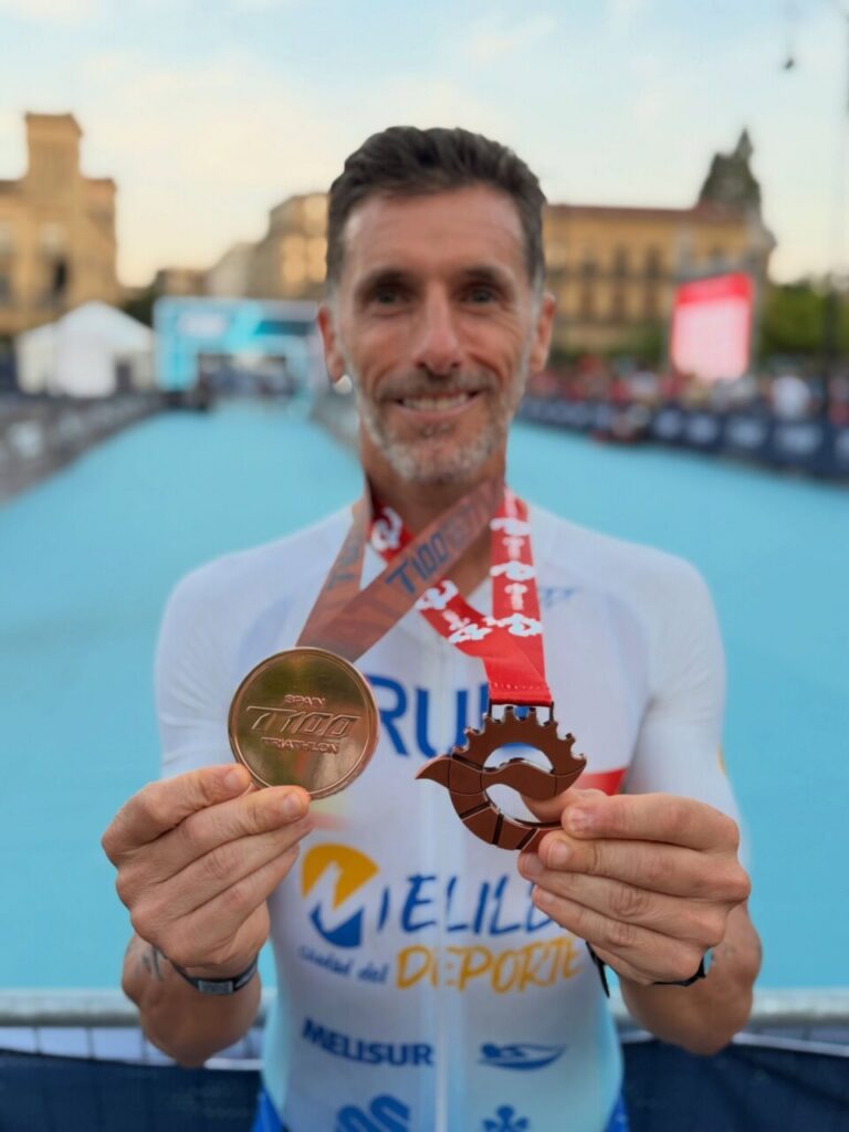 Luismi Ruiz sosteniendo medallas tras el triatlón en Pamplona