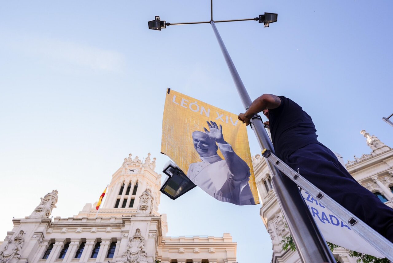 Persona colocando una bandera de León XIV en Madrid