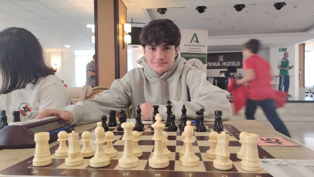 Joven ajedrecista en torneo con tablero y piezas de ajedrez
