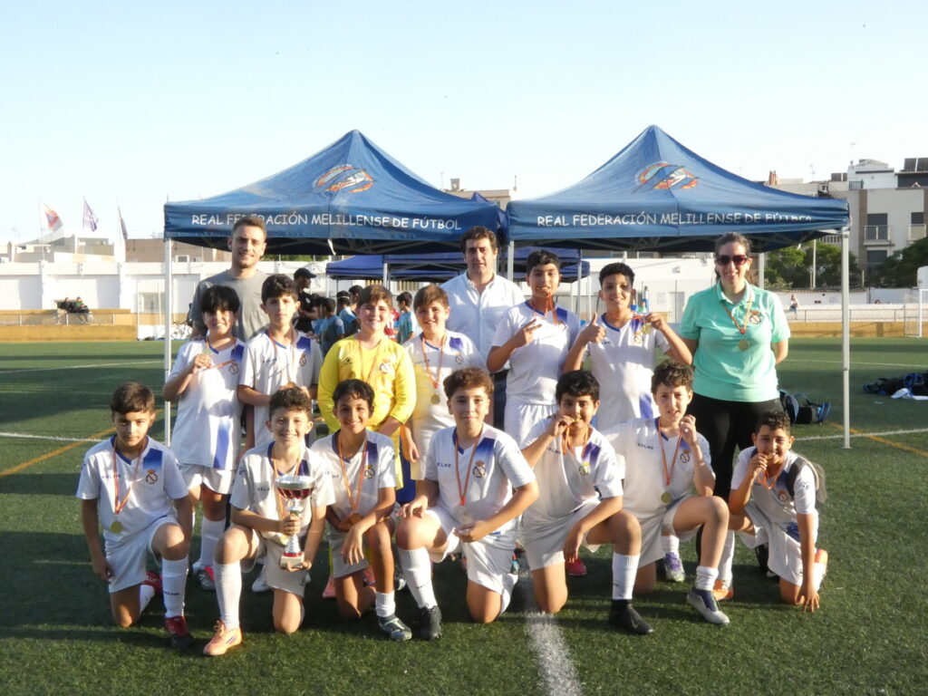 Grupo de niños alevines con trofeos en torneo de fútbol