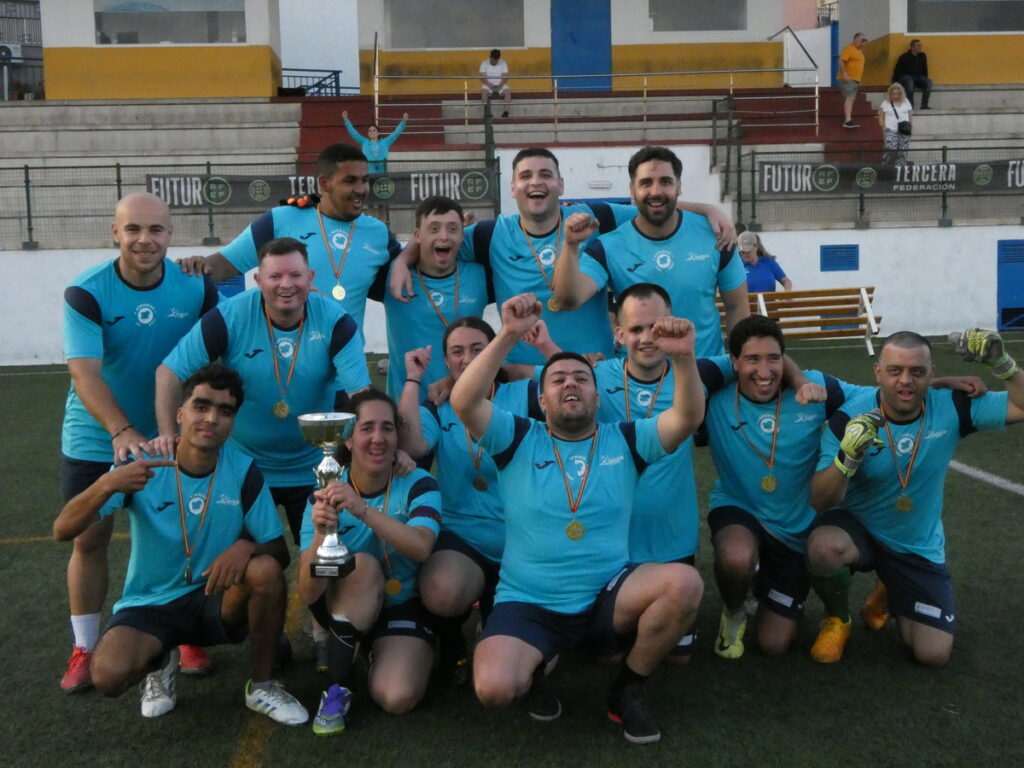 Grupo de jugadores celebrando con trofeo en el torneo de fútbol inclusivo