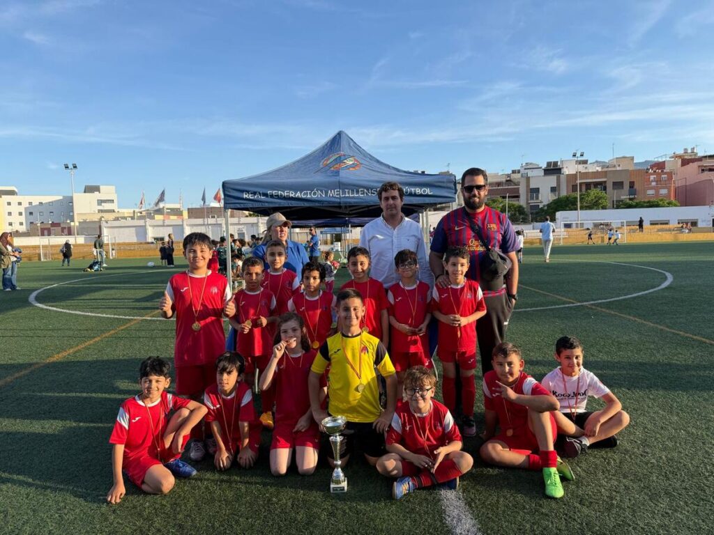 Niños posando con trofeos en el torneo de fútbol Prebenjamín