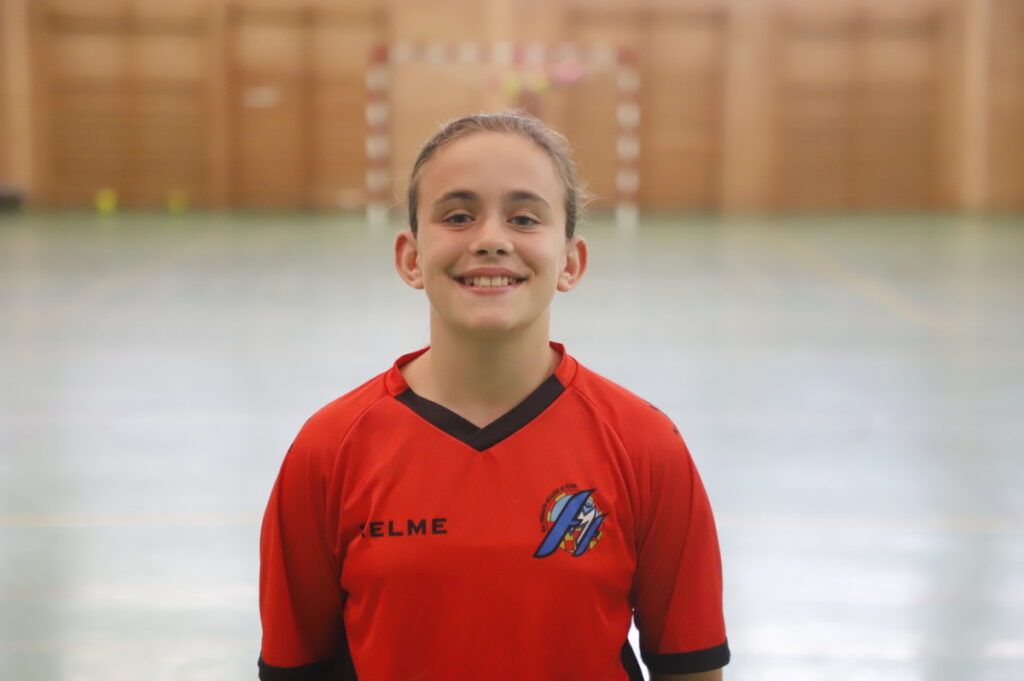 Jugadora de fútbol sala femenino sonriendo en su uniforme rojo