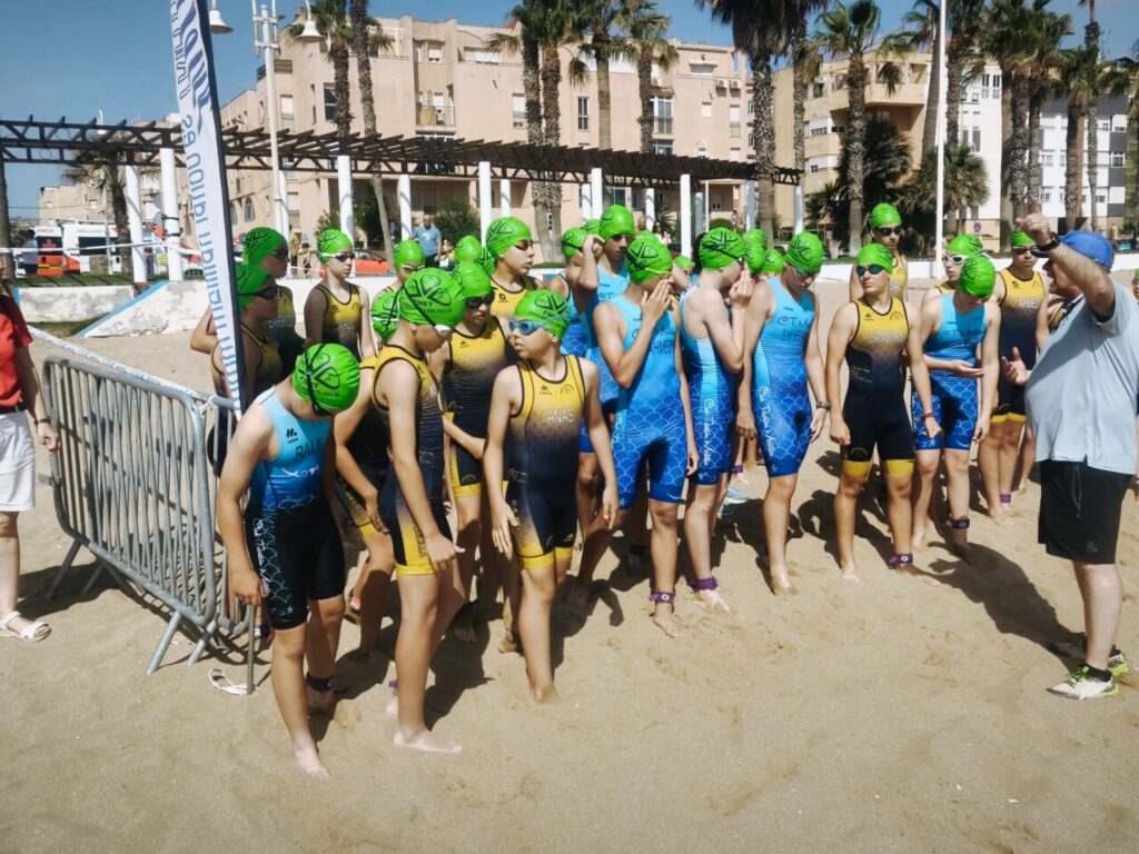 Grupo de triatletas jóvenes en la Playa del Hipódromo listos para competir