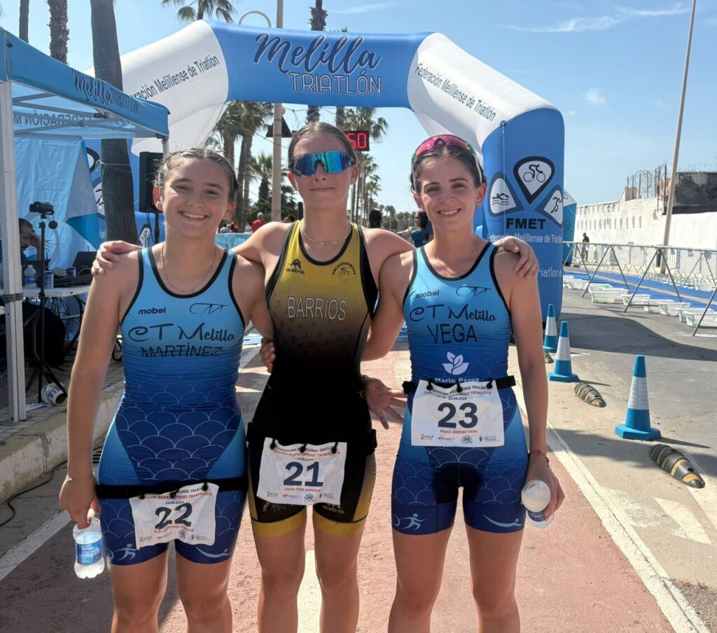 Tres triatletas posando en la Playa del Hipódromo durante el evento