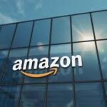 Amazon logo displayed on a glass office building against a blue sky