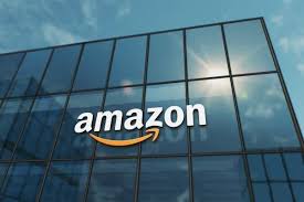 Amazon logo displayed on a glass office building against a blue sky