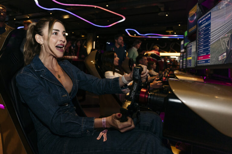 Mujer emocionada jugando en simulador de carreras en arcade