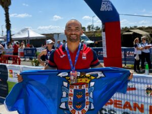 Atleta sosteniendo una bandera en un evento deportivo al aire libre