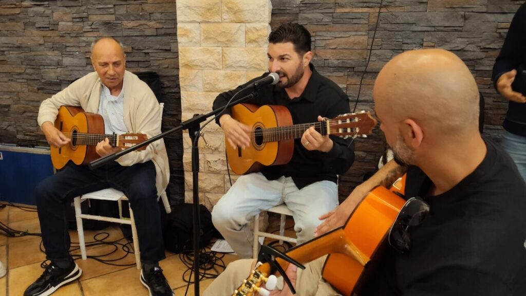 Alumnos de Aulas Culturales tocando guitarras en una fiesta de fin de curso.