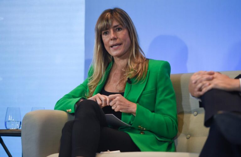 Begoña Gómez hablando en un evento con chaqueta verde