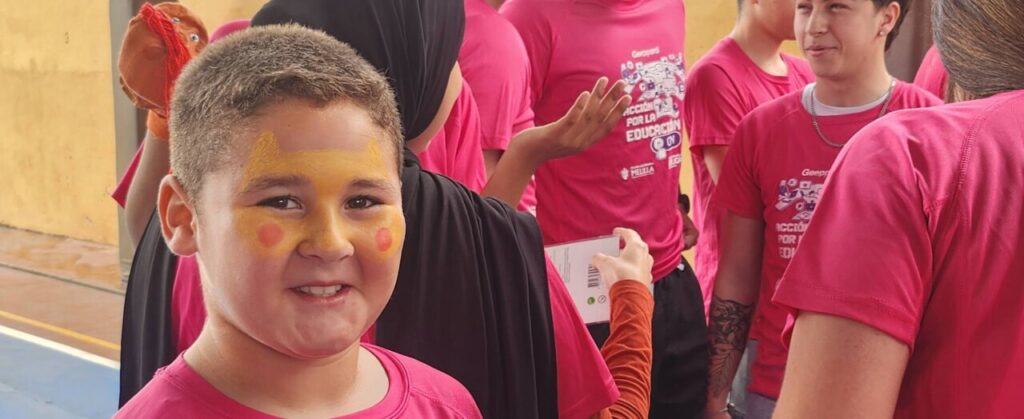 Niño sonriente con cara pintada en evento educativo en Melilla
