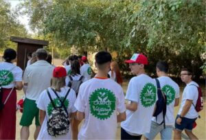 Grupo de jóvenes en un campo de voluntariado con camisetas blancas