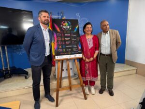 Presentación del festival Holi con un cartel colorido y tres personas sonriendo