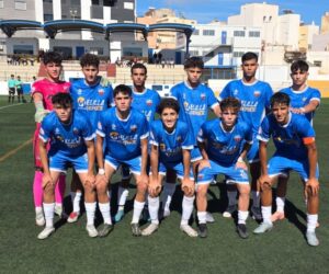 Equipo juvenil del C.F. Rusadir posando en el campo de fútbol