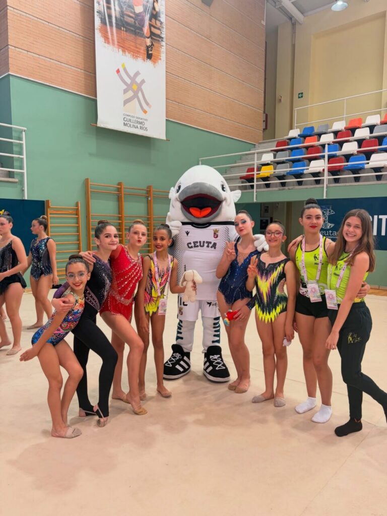Gimnastas del Club Ágora posando con la mascota en Ceuta