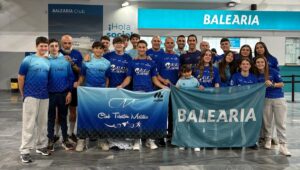 Miembros del Club Triatlón Melilla posando con banderas en un evento
