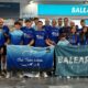 Miembros del Club Triatlón Melilla posando con banderas en un evento