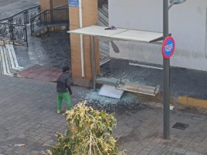 Hombre junto a una marquesina de autobús destrozada en Melilla