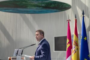 Emiliano García-Page hablando en un evento con banderas de España y Europa