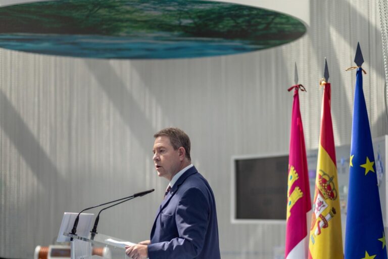Emiliano García-Page hablando en un evento con banderas de España y Europa