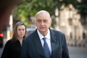 Jorge Fernández Díaz caminando mientras es observado por una mujer.