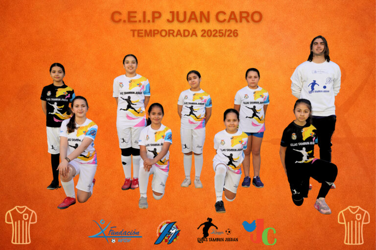 Group of children and a coach pose for a team photo on an orange backdrop, wearing white jerseys with colorful graphics for CEIP JUAN CARO • Temporada 2025/26.
