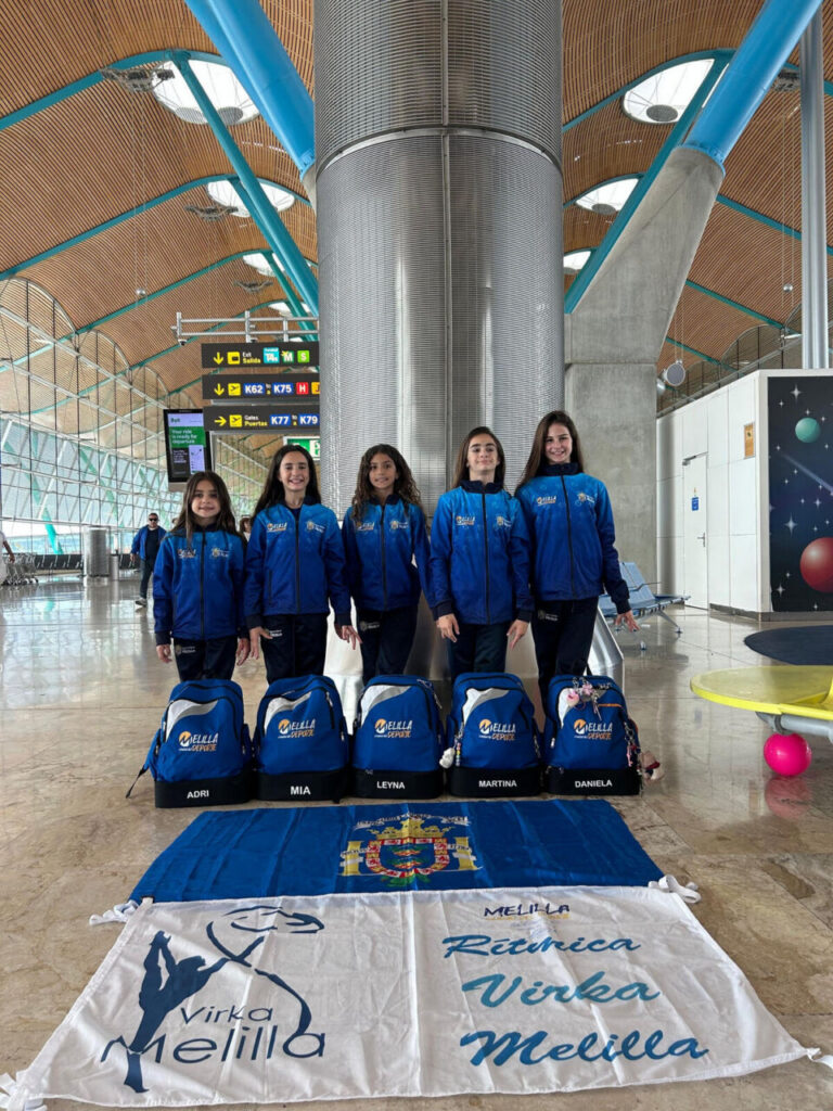 Gimnastas del Club Virka Melilla en el aeropuerto con mochilas y banderas