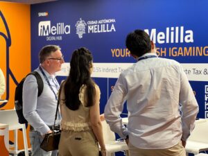 Personas observando un stand de iMelilla en un evento