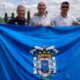 Jesús Carlos Martínez con compañeros sosteniendo una bandera en el torneo de golf