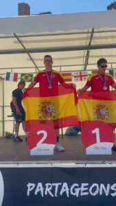 Jesús y Jorge sosteniendo banderas de España en el podio
